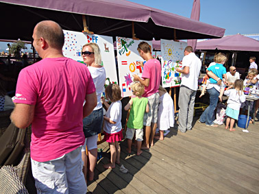 Workshop schilderen op het strand van Scheveningen tijdens een bedrijfsfeest. Gezamenlijk worden 3 schilderijen van 100 x 100 cm geschilderd tijdens een prachtige zomerdag. 